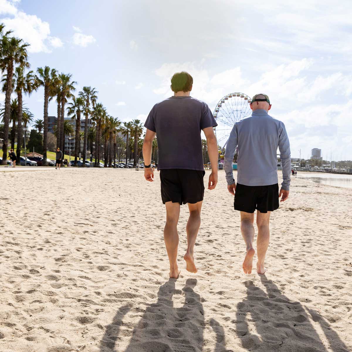 Two men walking along beach in Geelong after an appointment at Total Care Podiatry