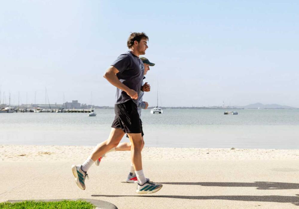 Two men running along Eastern Beach Geelong after consultation with Total Care Podiatry podiatrists